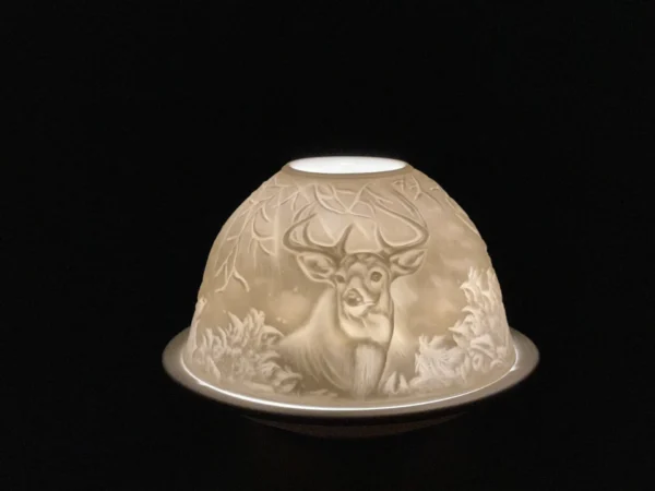 A white candle holder with a deer on it.