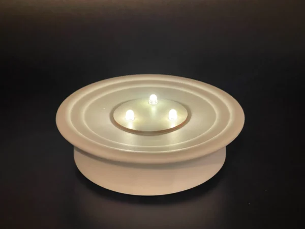 A candle holder with one lit candle on top of it.