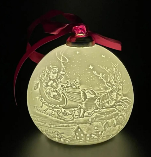 A christmas ornament with santa and sleigh on it.